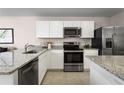 Modern kitchen featuring stainless steel appliances, white cabinetry, and granite countertops at 2307 Incandescent Way, South Daytona, FL 32119