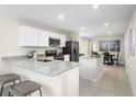 Open kitchen featuring white cabinets, stainless steel appliances, and granite countertops at 2307 Incandescent Way, South Daytona, FL 32119