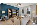 Bright living room featuring a plush sofa, stylish decor, and large windows at 3311 Grande Heron Dr, St Cloud, FL 34773
