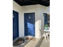 Apartment entrance with blue door, white walls, and outdoor seating area at 3651 N Goldenrod E Rd # 102, Winter Park, FL 32792