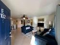Open-concept living room with tiled floor, ceiling fan, and view of kitchen at 3651 N Goldenrod E Rd # 102, Winter Park, FL 32792