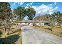 Charming one-story home with a well-maintained lawn, a long driveway, and a two-car garage at 4851 Ne 7Th St, Ocala, FL 34470