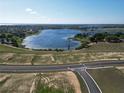 Scenic aerial view of a lake surrounded by new home construction in a planned community at 11057 Nellie Crossing Cir, Clermont, FL 34711