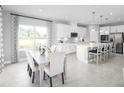 Bright kitchen and dining room features white cabinets, modern appliances, and eat-in island with seating at 11057 Nellie Crossing Cir, Clermont, FL 34711