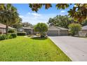 Traditional home with a well-maintained lawn and symmetrical curb appeal under a clear sky, showcasing a welcoming entryway at 8929 Sw 196Th Ct, Dunnellon, FL 34432