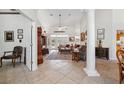Open-concept living room with tall ceilings, tile flooring, a decorative pillar, and French doors to the outdoor space at 8929 Sw 196Th Ct, Dunnellon, FL 34432