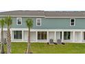 Rear exterior view showing the white, covered patio area and lawn space of the townhome at 1129 Red Buckeye Ct, Deland, FL 32720