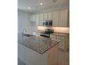 Modern kitchen features stainless steel appliances, granite counters, and recessed lighting at 1129 Red Buckeye Ct, Deland, FL 32720