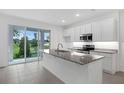Modern kitchen features an island, granite countertops, and stainless steel appliances at 1133 Red Buckeye Ct, Deland, FL 32720