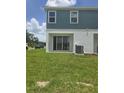 View of the backyard with sliding glass doors and green lawn at 1145 Red Buckeye Ct, Deland, FL 32720
