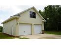 Two-car garage with an upstairs window and a door at 1315 Veech Rd, Leesburg, FL 34748