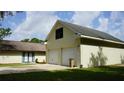 A two-car garage with upstairs window and a long concrete driveway at 1315 Veech Rd, Leesburg, FL 34748