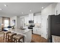 Open-concept kitchen featuring white cabinets, stainless steel appliances, granite countertops and breakfast bar seating at 6408 Domizio Dr, Winter Haven, FL 33884