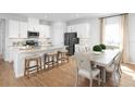 Modern kitchen with an island, breakfast bar, stainless appliances, and an adjacent dining area at 6501 Domizio Dr, Winter Haven, FL 33884