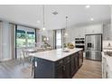 Modern kitchen with stainless steel appliances, a large center island, quartz countertops, and pendant lighting fixtures at 823 Emerald Grove Dr, Apopka, FL 32703