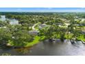 Aerial view of a home near a lake surrounded by trees, with a pool and enclosed patio at 1148 Rosetta Dr, Deltona, FL 32725