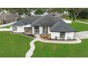 Stunning home featuring a white exterior, manicured lawn, complemented by a beautiful landscape and walkway at 1148 Rosetta Dr, Deltona, FL 32725