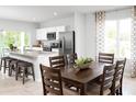 Dining room features a wooden dining table set, alongside the open kitchen and a view of the outdoors at 1203 Port Blue Way, Lady Lake, FL 32159