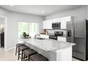Open kitchen with stainless steel appliances, granite countertops, seating at the island, and tiled flooring at 1203 Port Blue Way, Lady Lake, FL 32159