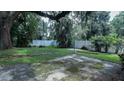 The backyard features a mature tree canopy, a white fence, a patio and established planting beds at 423 E Kaley St, Orlando, FL 32806