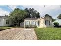 Charming home with stone driveway and walkway, blue shutters and siding, and well-manicured landscaping at 423 E Kaley St, Orlando, FL 32806