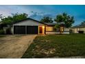 Attractive one-story home features a two-car garage and green lawn at 7289 Lake Floy Cir, Orlando, FL 32819
