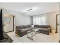Comfortable living room with a modern light fixture, neutral colors, and a large sectional sofa at 7289 Lake Floy Cir, Orlando, FL 32819