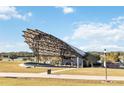 Lakeside community amphitheater with a unique sunshade design sits amongst large green space and sidewalk access at 741 Mystic Gardens Dr, Apopka, FL 32703