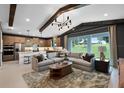 Open concept living room with a modern sofa, area rug, and sliding glass doors overlooking the backyard at 764 Mystic Gardens Dr, Apopka, FL 32703