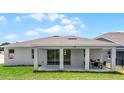Rear exterior showing the covered patio with outdoor seating and sliding glass doors at 847 Emerald Grove Dr, Apopka, FL 32703