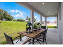 Inviting covered patio with rustic wood table and seating overlooking a lush green lawn at 847 Emerald Grove Dr, Apopka, FL 32703