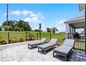 This backyard has three lounge chairs, a fence, and a green space at 855 Emerald Grove Dr, Apopka, FL 32703