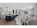 Open-concept living area features a stylish dining table, kitchen island with seating, and a cozy living space at 855 Emerald Grove Dr, Apopka, FL 32703