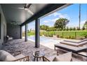 Covered patio offers ample seating with a view of the refreshing inground pool and lush backyard at 855 Emerald Grove Dr, Apopka, FL 32703