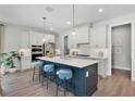 Modern kitchen with a large center island, stainless steel appliances, and stylish pendant lighting at 628 Mystic Gardens Dr, Apopka, FL 32703