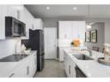 Modern kitchen with stainless steel appliances, white cabinetry and a breakfast bar at 10816 Sw 72Nd Cir, Ocala, FL 34476