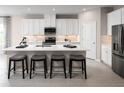 Stylish kitchen with sleek white cabinets, a central island with barstools, and modern appliances at 10919 Sw 73Rd Ct, Ocala, FL 34476