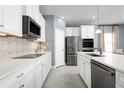 Well-equipped kitchen featuring stainless steel appliances and white cabinets at 1156 Ivy Manor St, Minneola, FL 34715