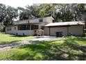 Exterior showcasing a two-story home, attached garage, and a screened porch at 5635 Kimball Rd, Mulberry, FL 33860