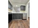 Kitchen featuring stainless steel appliances, sleek gray cabinets, and wood-look flooring at 3006 S Semoran Blvd # 7, Orlando, FL 32822