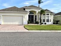 Charming single-story home with a two-car garage, manicured lawn, and beautiful tropical landscaping at 255 Royal Palm Dr, Davenport, FL 33837