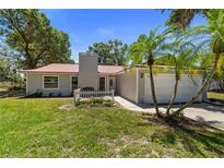 Charming single-story home featuring a red roof, white picket fence, and well-maintained landscaping at 3240 Flamingo Ln, Mulberry, FL 33860
