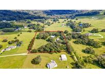 Expansive aerial view of the property, showing the large acreage with trees, green fields, and outlined property lines at 4292 Sw 73Rd Trl, Bushnell, FL 33513