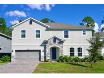 Charming two-story home boasts a stone entryway, inviting curb appeal, and a well-manicured lawn at 29912 Cypress Pointe, Deer Island, FL 32778
