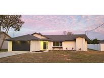 Charming single story home featuring a modern gray roof, fresh landscaping, and a two-car garage at 2469 Courtland Blvd, Deltona, FL 32738