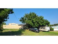 View of the property with a mature tree, an recreational vehicle, and a truck at 1505 N Peninsula Ave, New Smyrna Beach, FL 32169