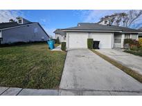 Front view of a gray house with a two-car garage and well-maintained lawn at 4520 Summergrove Ave, Orlando, FL 32812