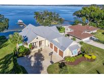 Waterfront home with expansive lake views, large yard, and three-car garage at 12943 Se Sunset Harbor Rd, Weirsdale, FL 32195