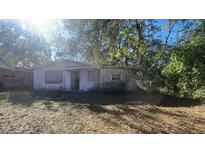 Ranch-style house needing renovation, situated on a lot with mature trees at 109 Hibiscus Ave, Davenport, FL 33837