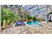 Relaxing pool area with patio furniture under a screened-in enclosure at 1457 Olympic Club Blvd, Champions Gate, FL 33896